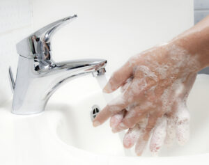 Photo showing a person washing their hands thoroughly with soap under running water