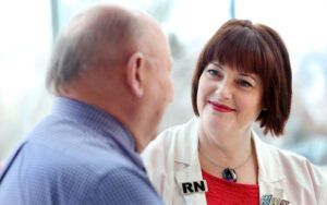Woman health professional sitting with cancer patient