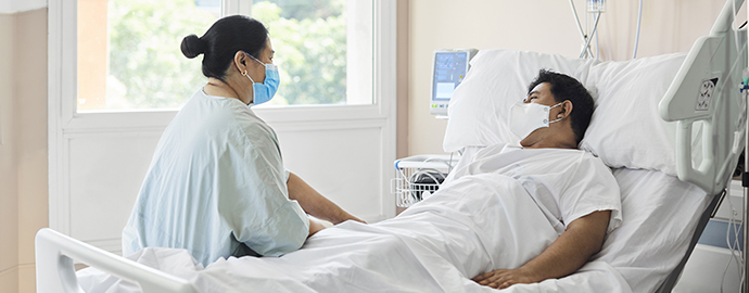 Woman Visiting Male Patient in Hospital Ward