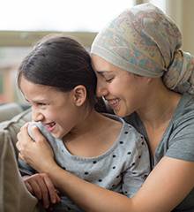 Woman with cancer hugging daughter